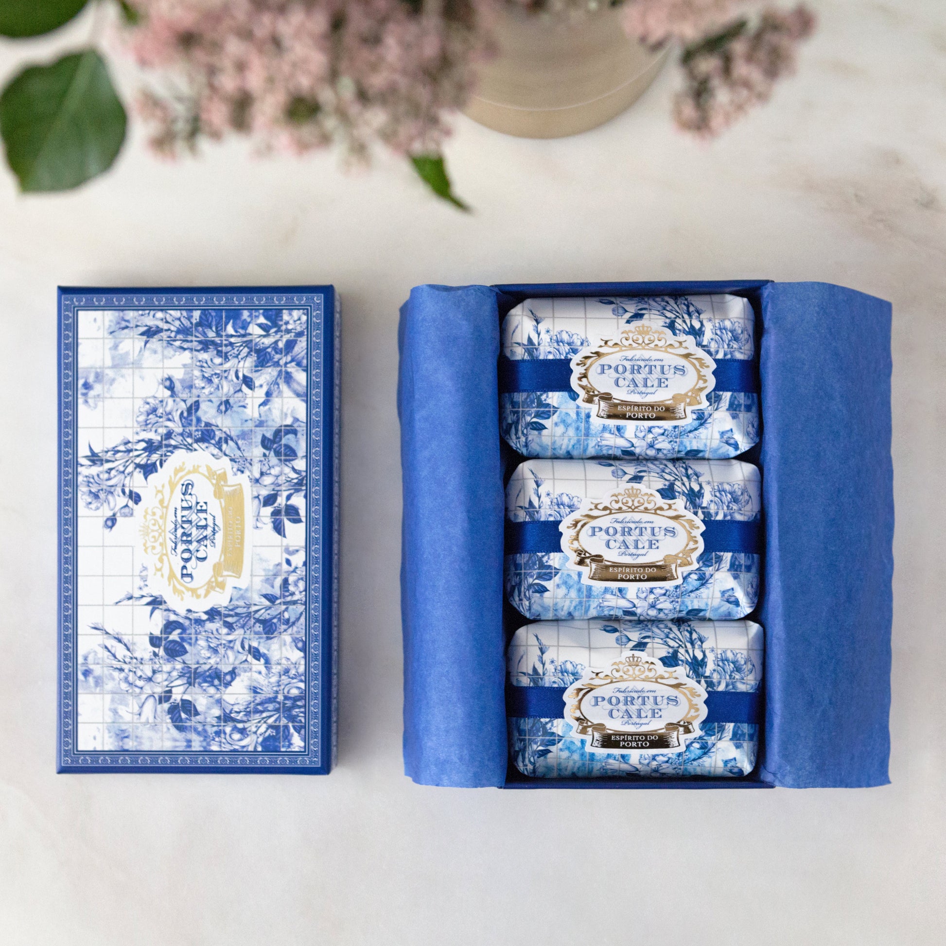 Three portus cale gold and blue soaps wrapped in decorative paper in a gift box