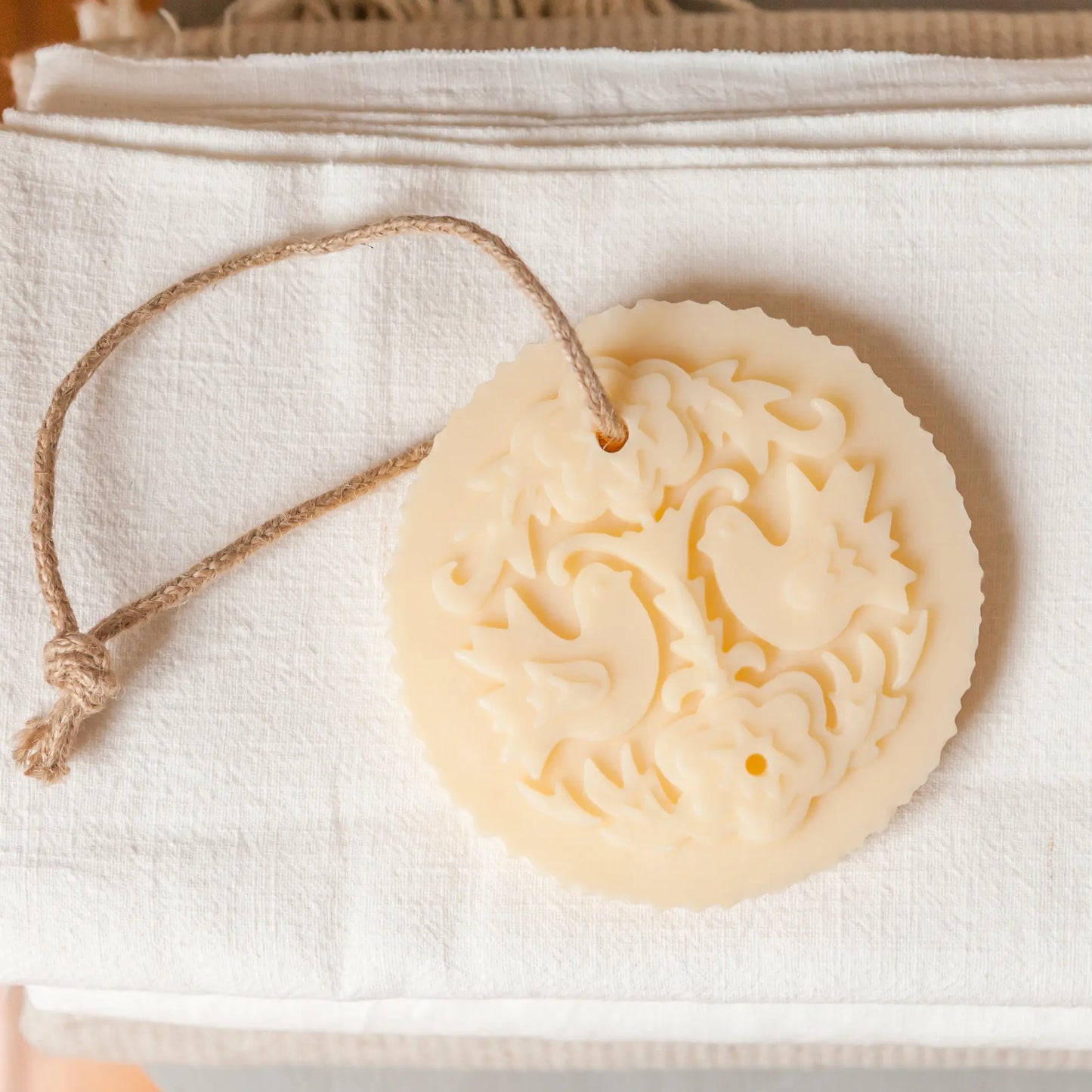 Castelbel Lovebirds Cedar & Rose Soap on Rope displayed on a textured white fabric surface — Cedar & Rose wardrobe freshener
