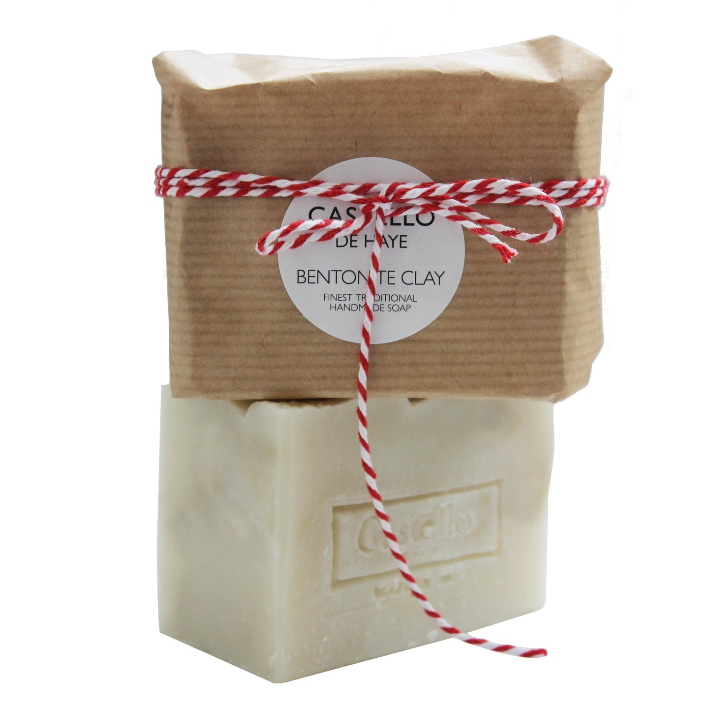 A natural beige bar of soap with exfoliating bentonite clay, wrapped in sustainable kraft paper with red and white bakers twine, labeled with the brand 'Castello De Haye' and product name 'Bentonite Clay Soap'.