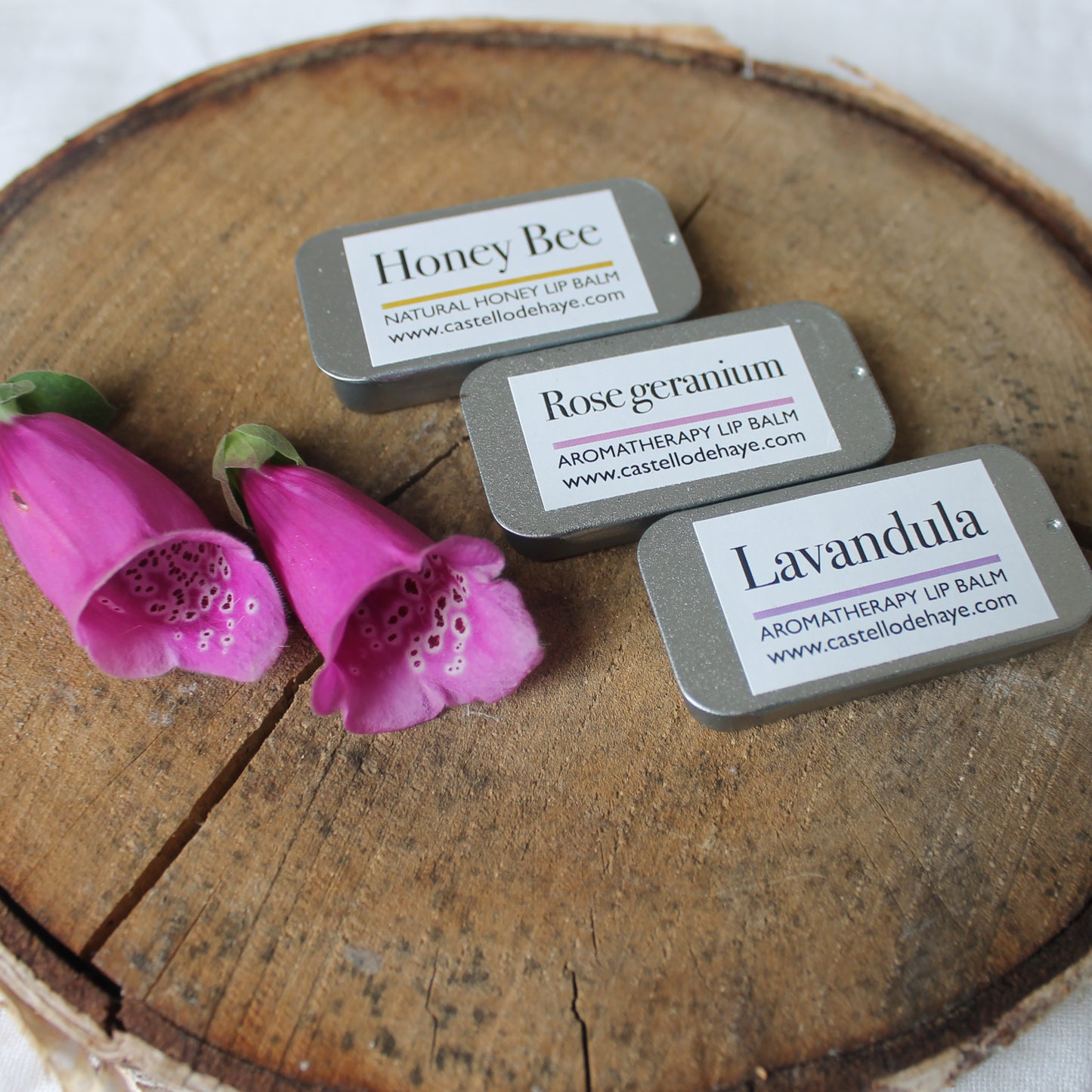 castello de Haye natural lip balms, Honey Bee, Rose Geranium and Lavandula on a wooden tray