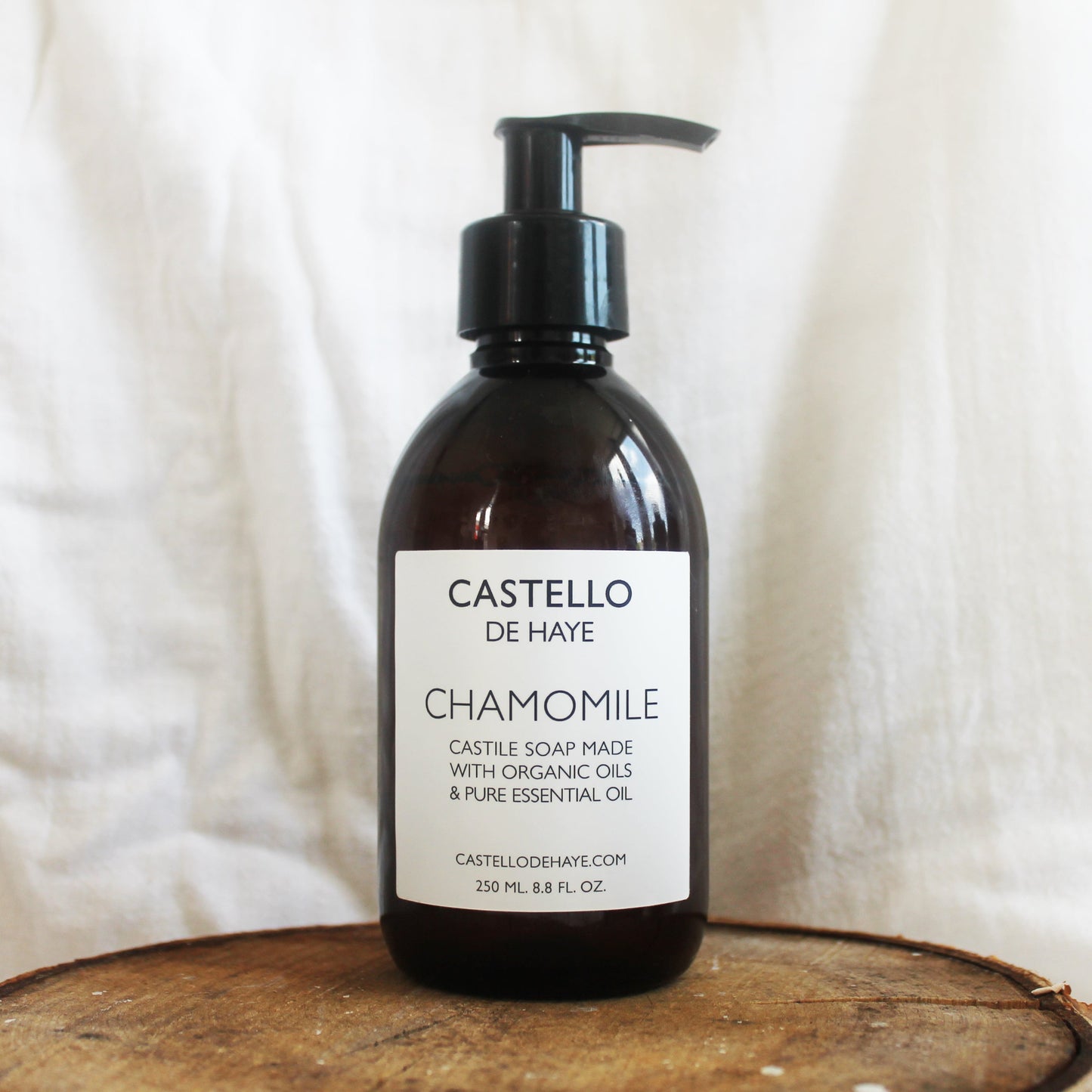 Castello de Haye Chamomile Castile Liquid Soap on a wooden board with linen background