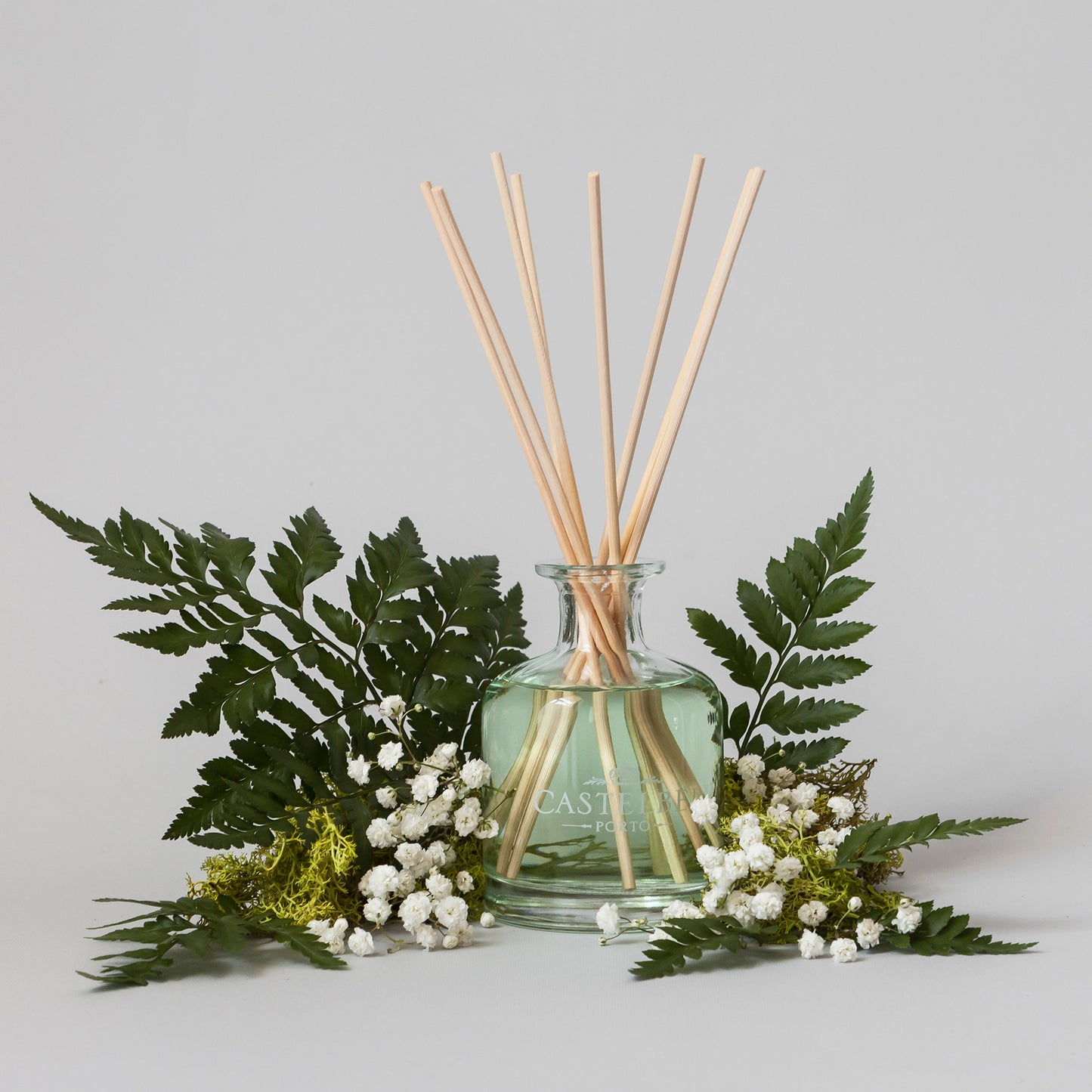 Verbena Reed diffuser with natural sticks and green leaves on a light gray background from Portus Cale in Portugal