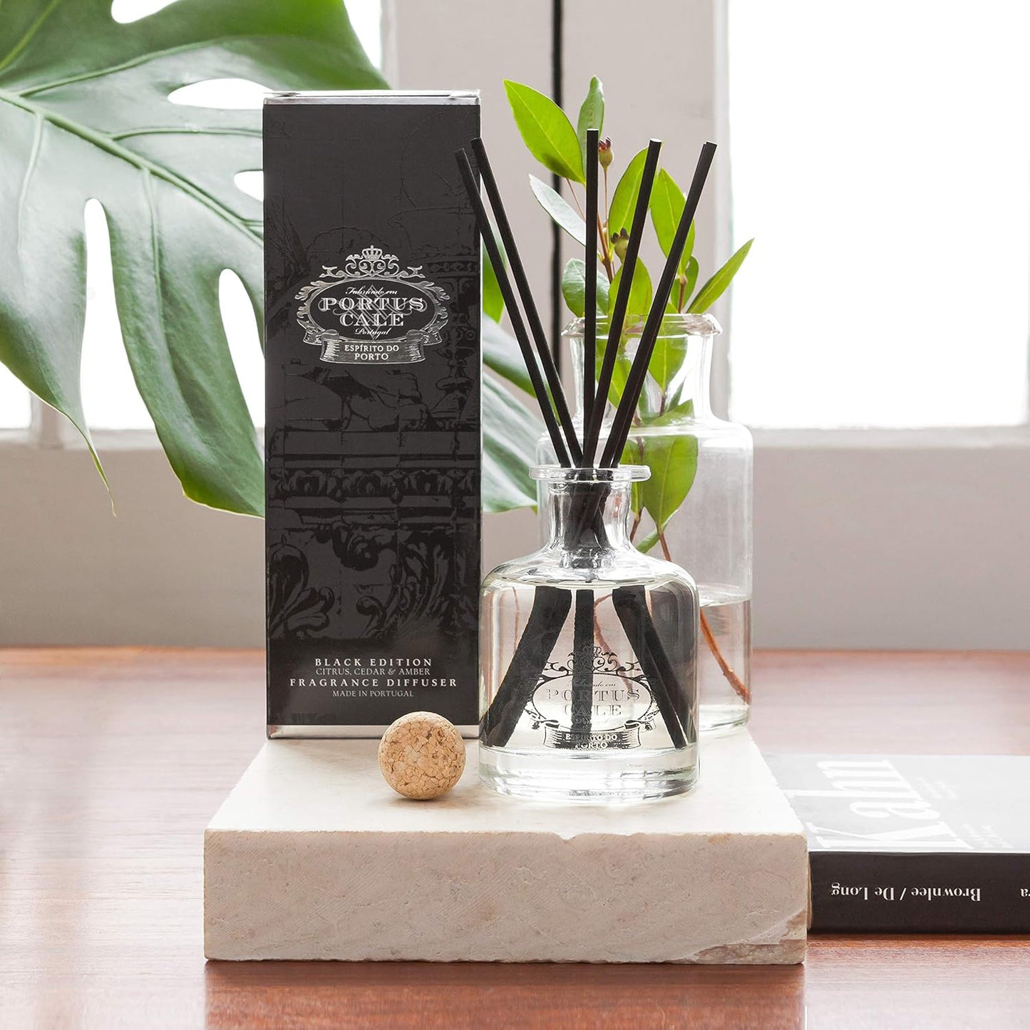 A diffuser with reeds and a box labeled 'Portus Cale' on a marble surface.
