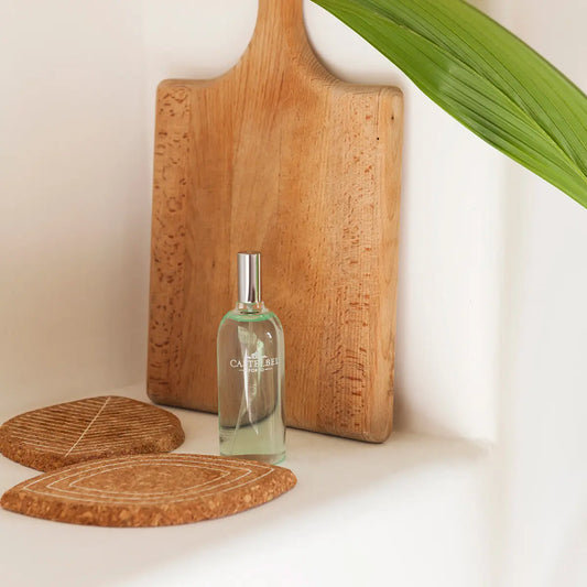 Castelbel Verbena Room Mist on a white shelf next to a wooden cutting board