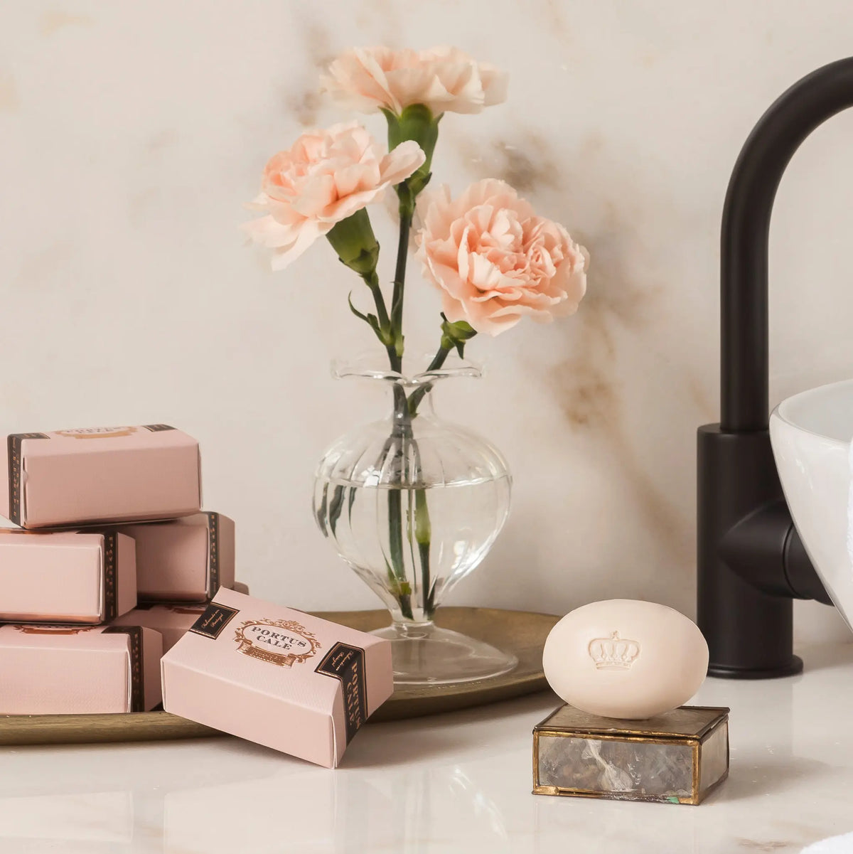 Portus Cale Rosé Blush soap bar and pink pillow boxes styled on a marble bathroom counter with pink carnations – Castelbel Portugal