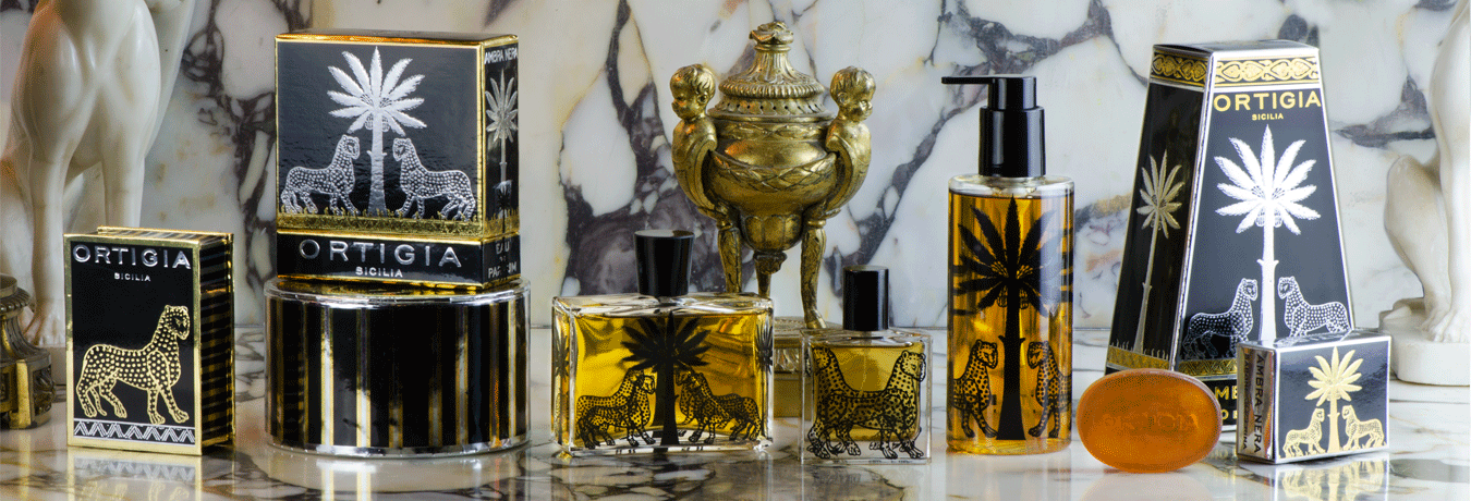 Collection of Ortigia perfume bottles on a marble surface with decorative elements.