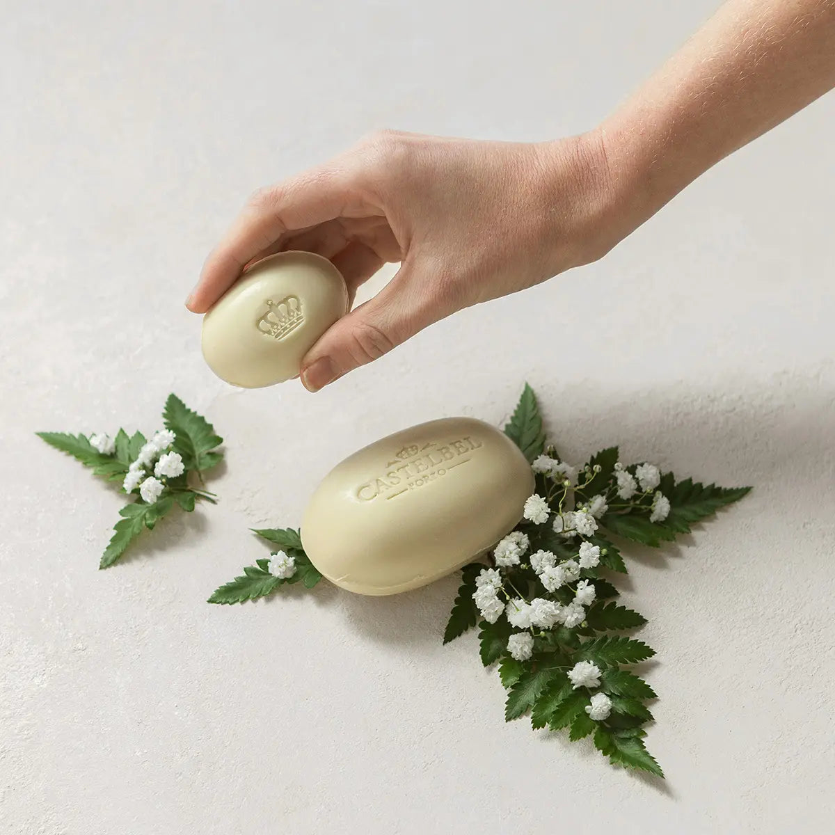 Castelbel Verbena 40g soap bar held by hand with white flowers – natural citrus soap