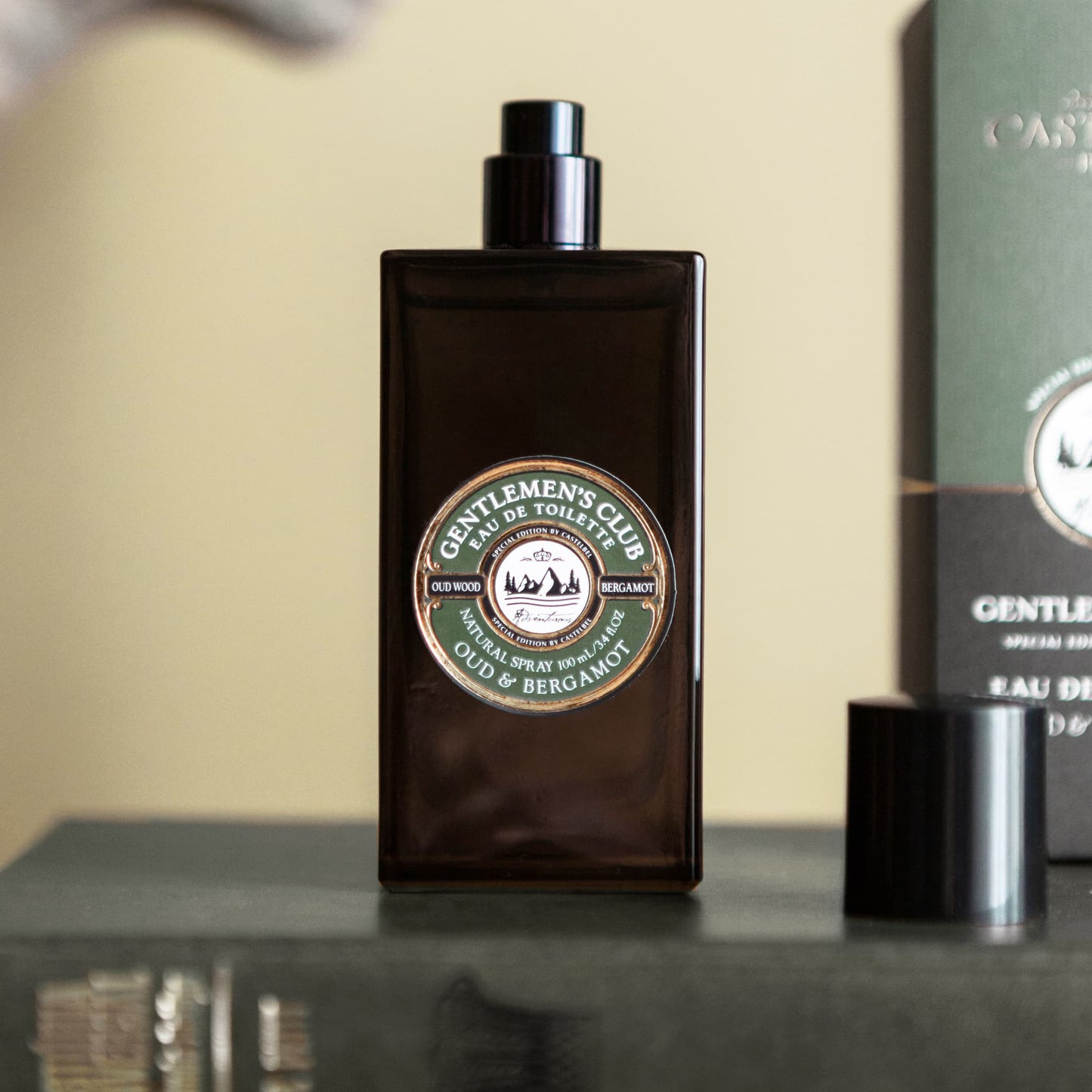 Castelbel Gentlemen's Club Oud & Bergamot Eau de Toilette styled on a leather bound book with cap removed and packaging in the background