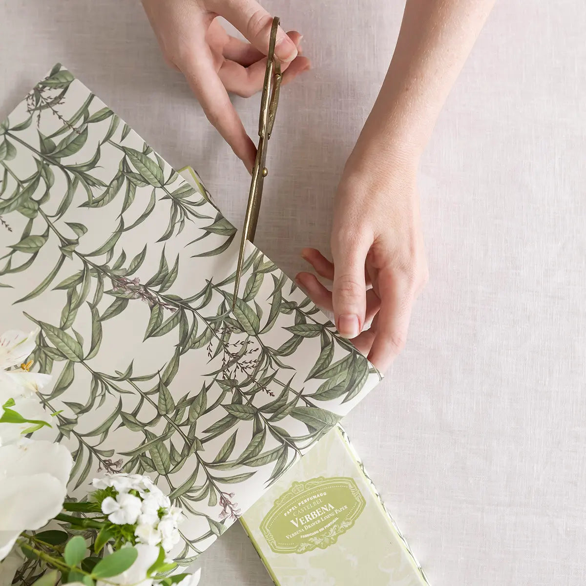Person cutting a Castelbel verbena-patterned drawer liners