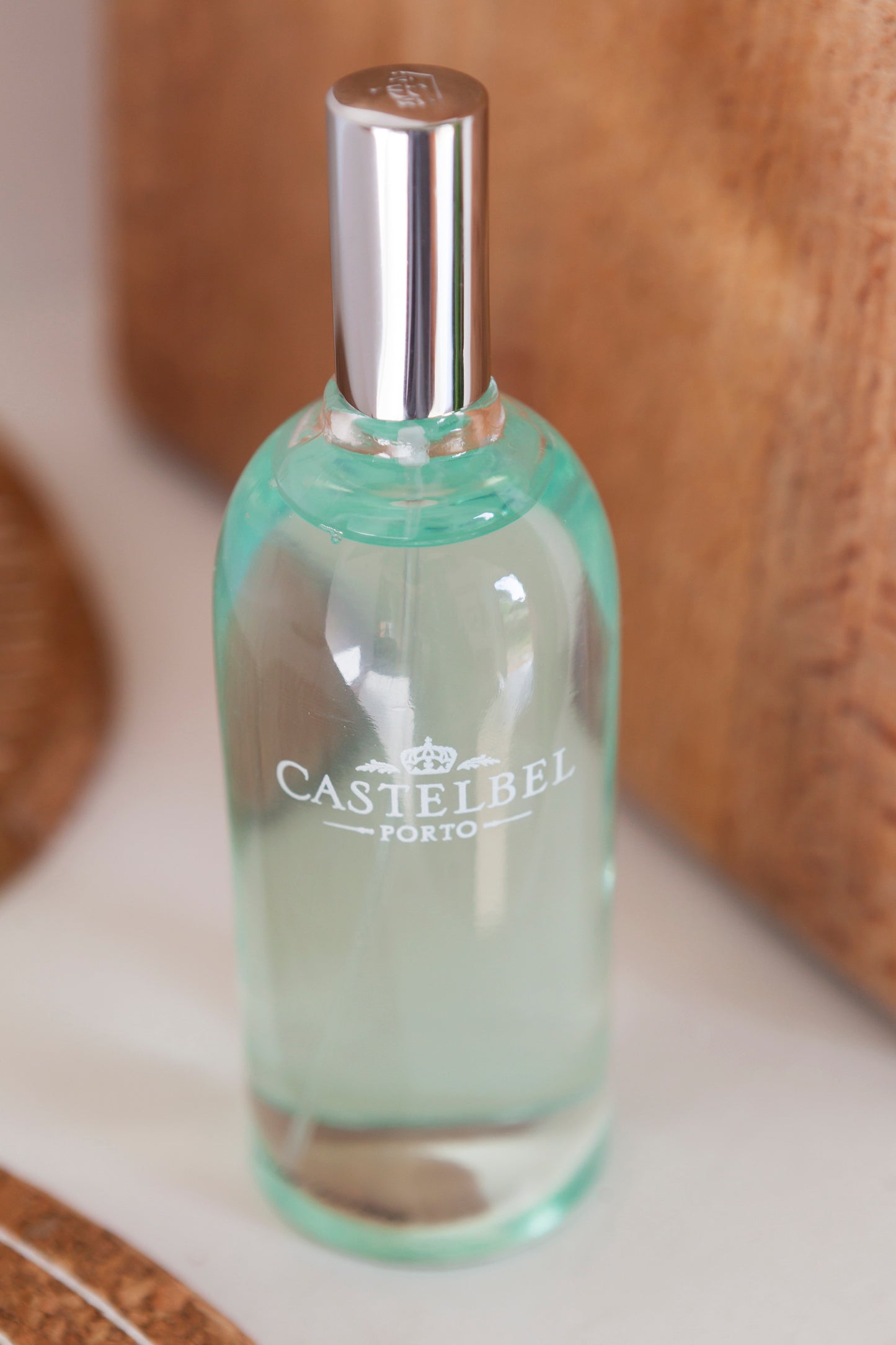 Clear bottle with silver cap on a wooden surface, featuring 'Castelbel' branding.