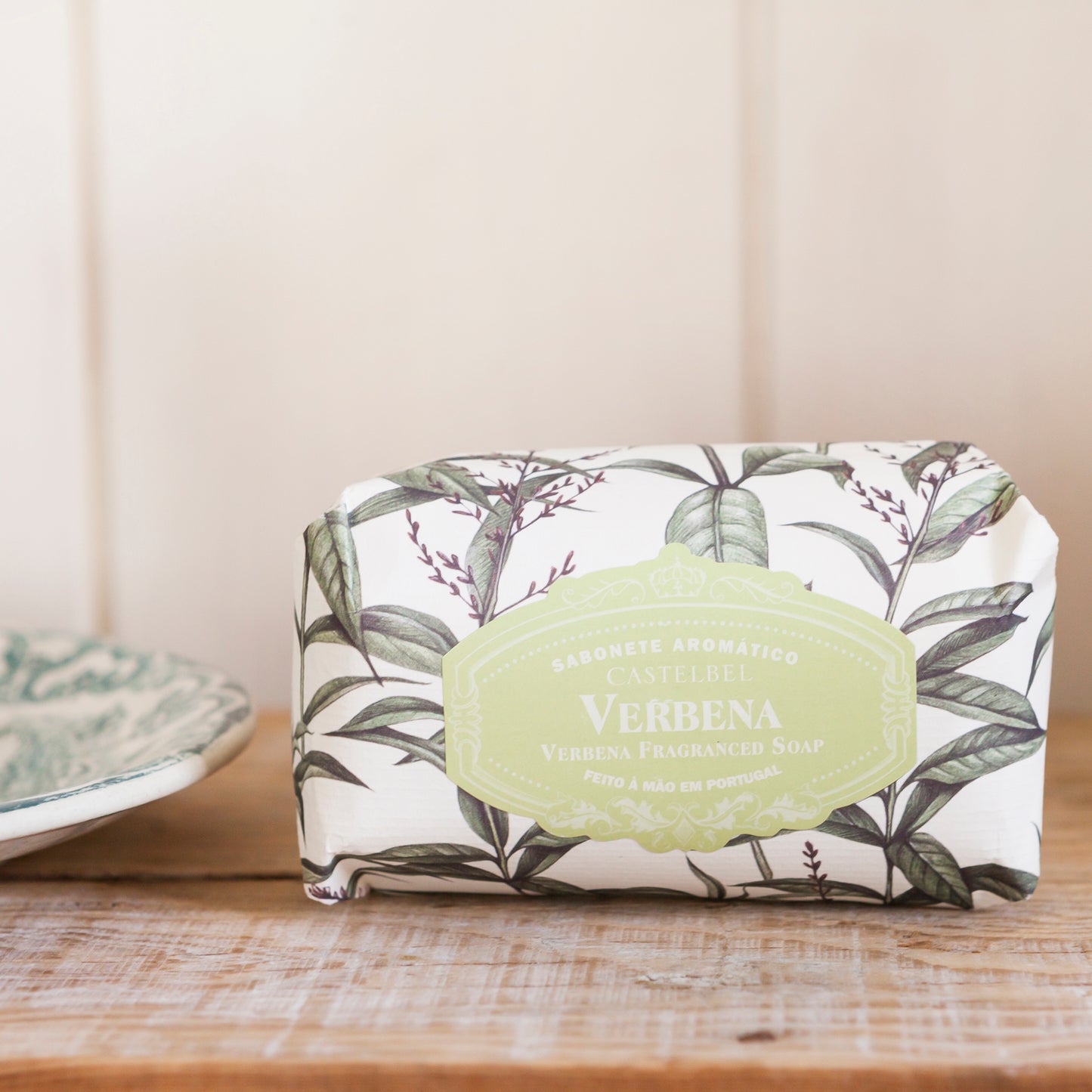 Bar of soap with a botanical design and 'Verbena' label on a wooden surface.