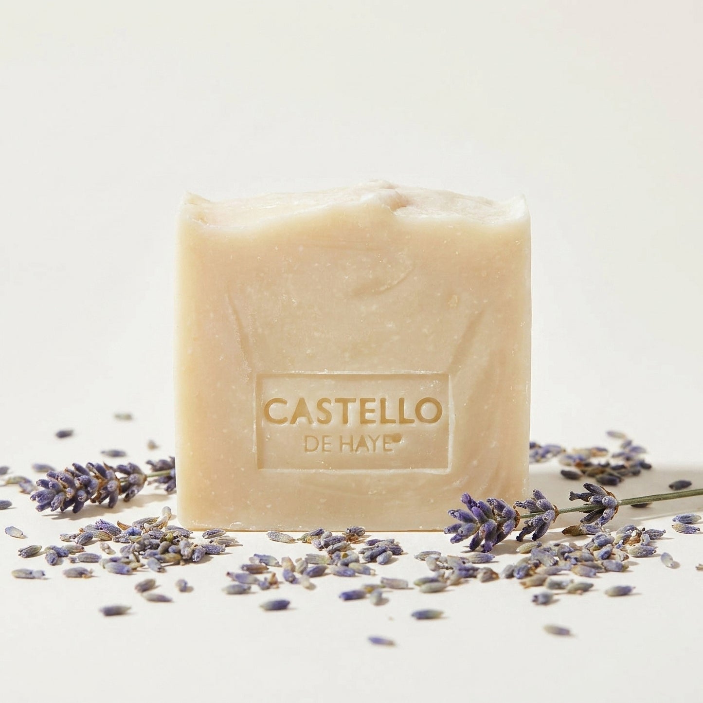 Castello de Haye natural lavender soap bar surrounded by fresh lavender petals