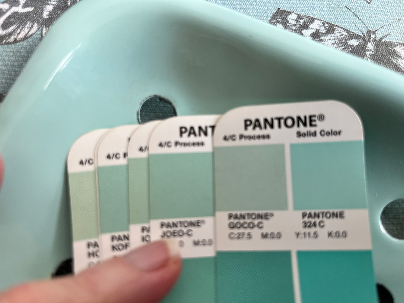 Pantone colour swatch card held against enamel green soap dish