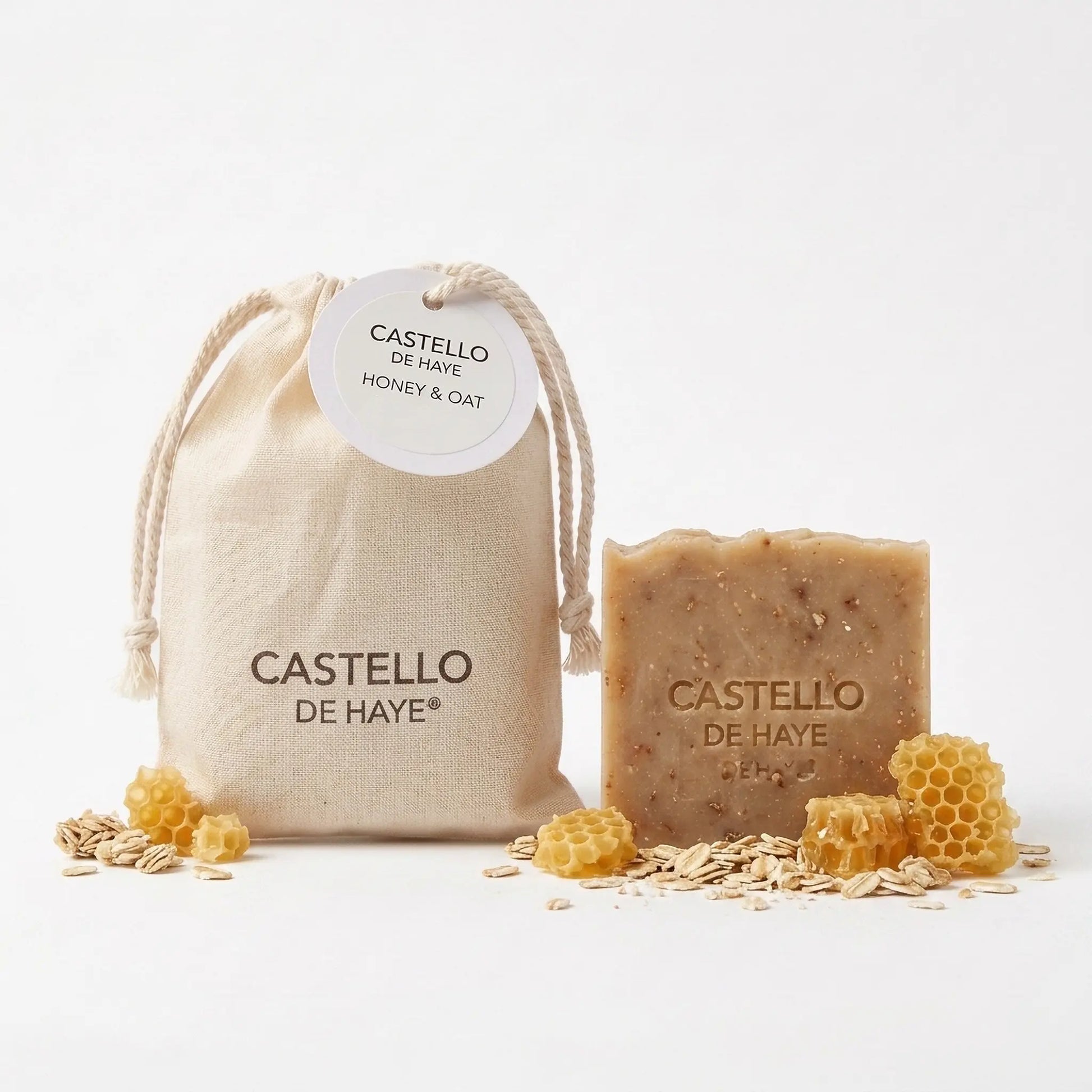 Honey & Oat soap bar with muslin gift bag, honeycomb and oats flat lay by Castello de Haye