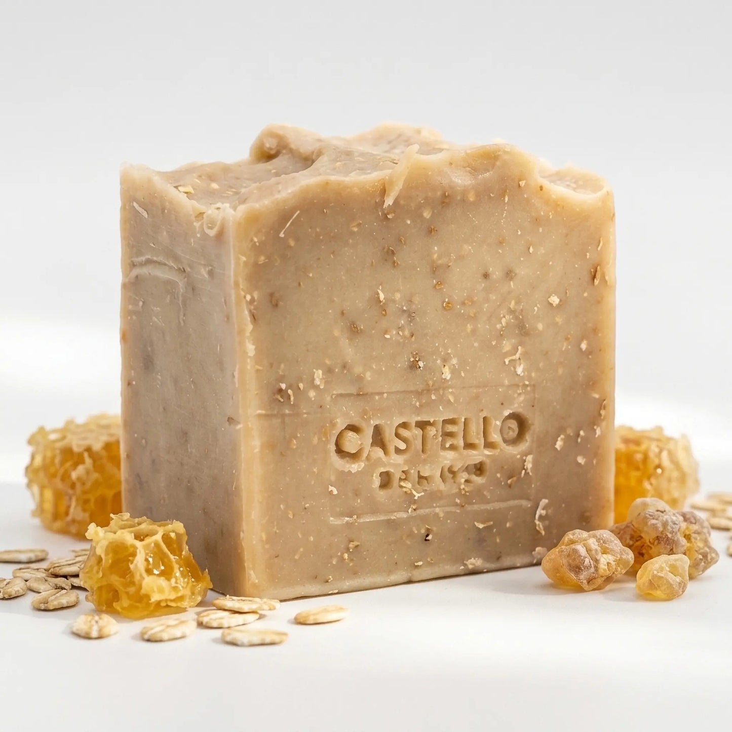 Castello de Haye Honey & Oat handmade soap bar with honeycomb pieces, oats and benzoin resin on white background