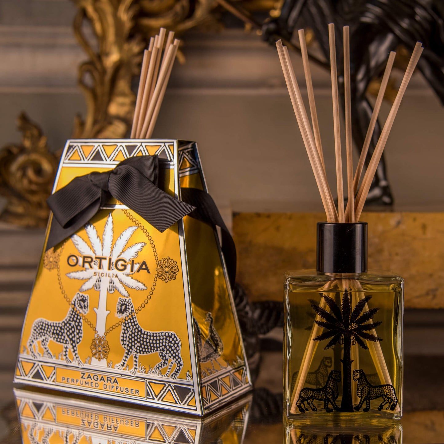 A perfume diffuser set from Ortigia, featuring a signature bottle with natural reeds and a decorative box, with a rich citrus scent.