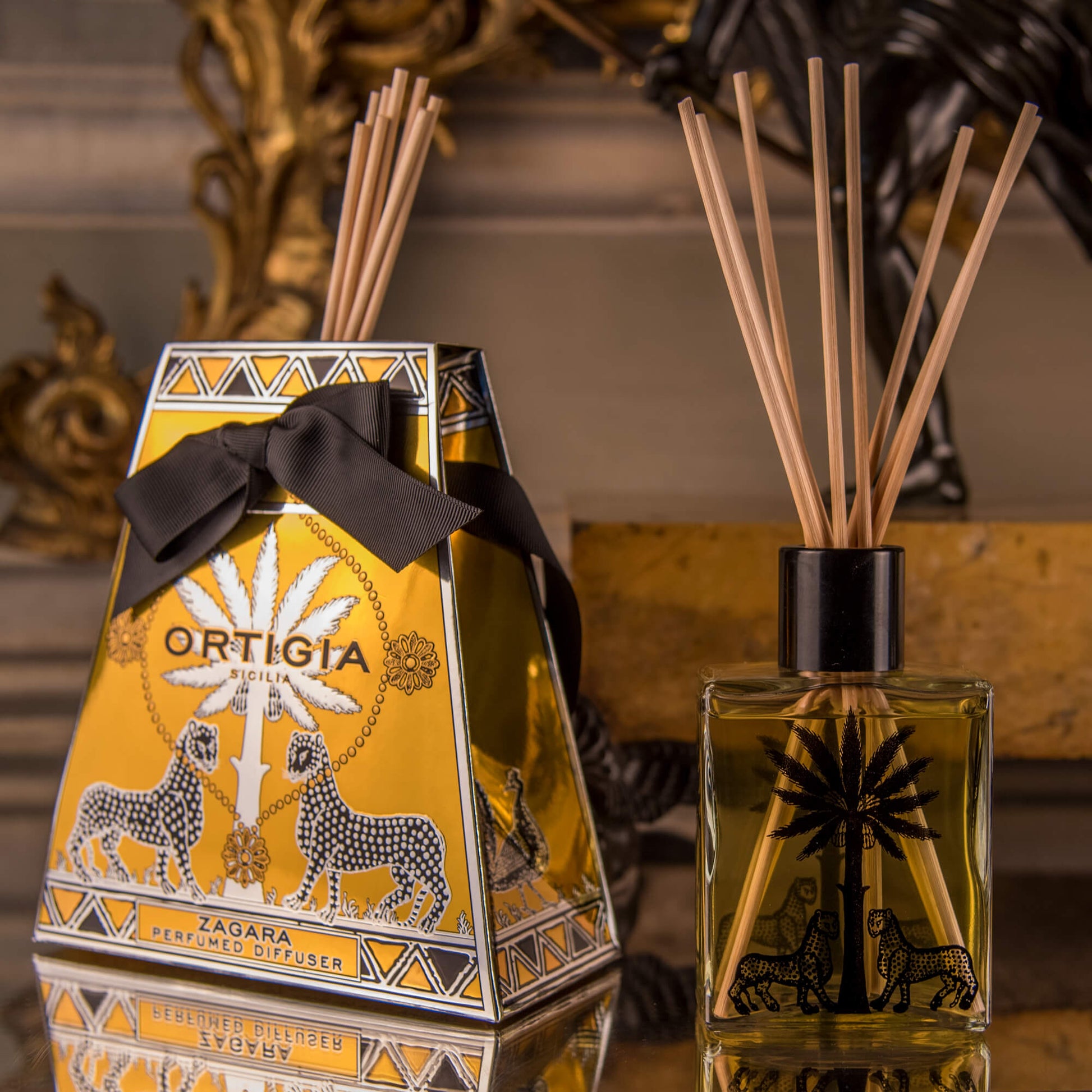 A perfume diffuser set from Ortigia, featuring a signature bottle with natural reeds and a decorative box, with a rich citrus scent.