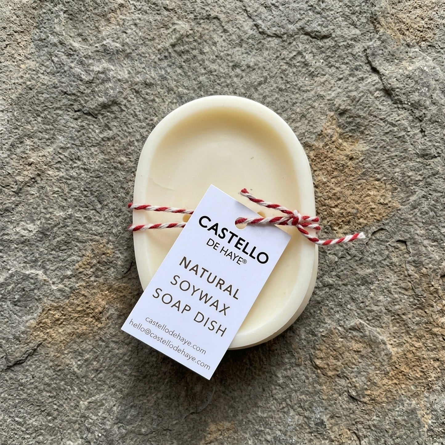 Castello de Haye oval soy wax soap dish in white, tied with red and white twine.