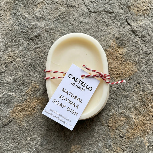 Castello de Haye oval soy wax soap dish in white, tied with red and white twine.