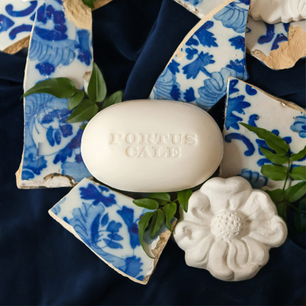 Bar of soap with 'Portus Cale' branding on a decorative blue and white ceramic dish.