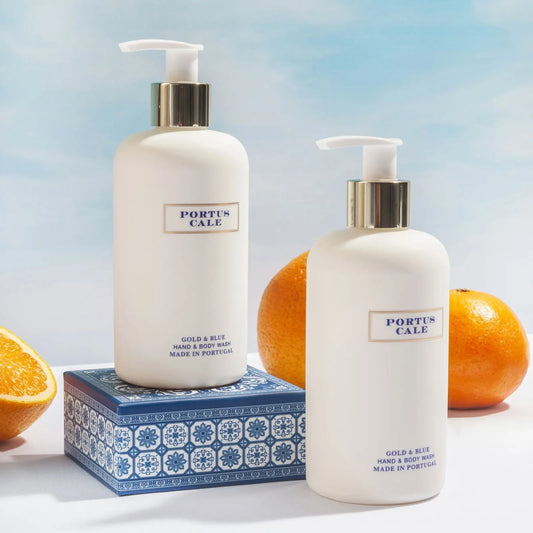 Portus Cale Gold & Blue hand & body wash bottles on a blue tile-pattern box with fresh oranges