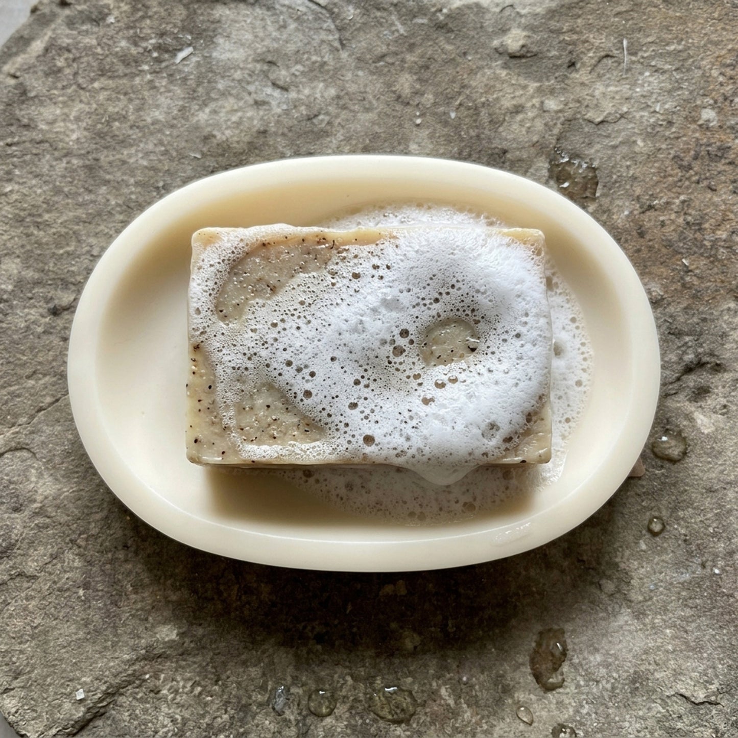 Castello de Haye handmade soap lathering on a white oval soy wax soap dish