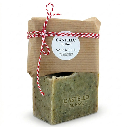 Castello de Haye Wild Nettle & Verbena soap bar 200g, unwrapped bar showing green nettle-speckled texture with kraft paper wrapped bar and red twine stacked on top, white background.