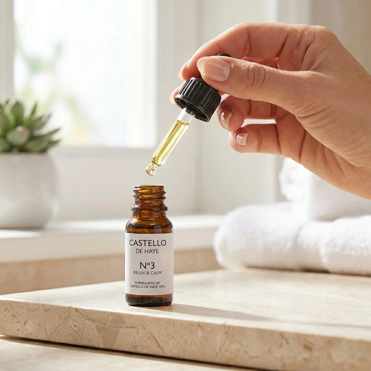 Female hand using pipette dropper over No.3 Ylang Ylang, Lavender & Sweet Orange essential oil blend 10ml — Castello de Haye